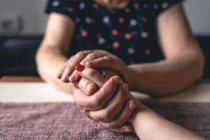 old and young man holding hands, close up.